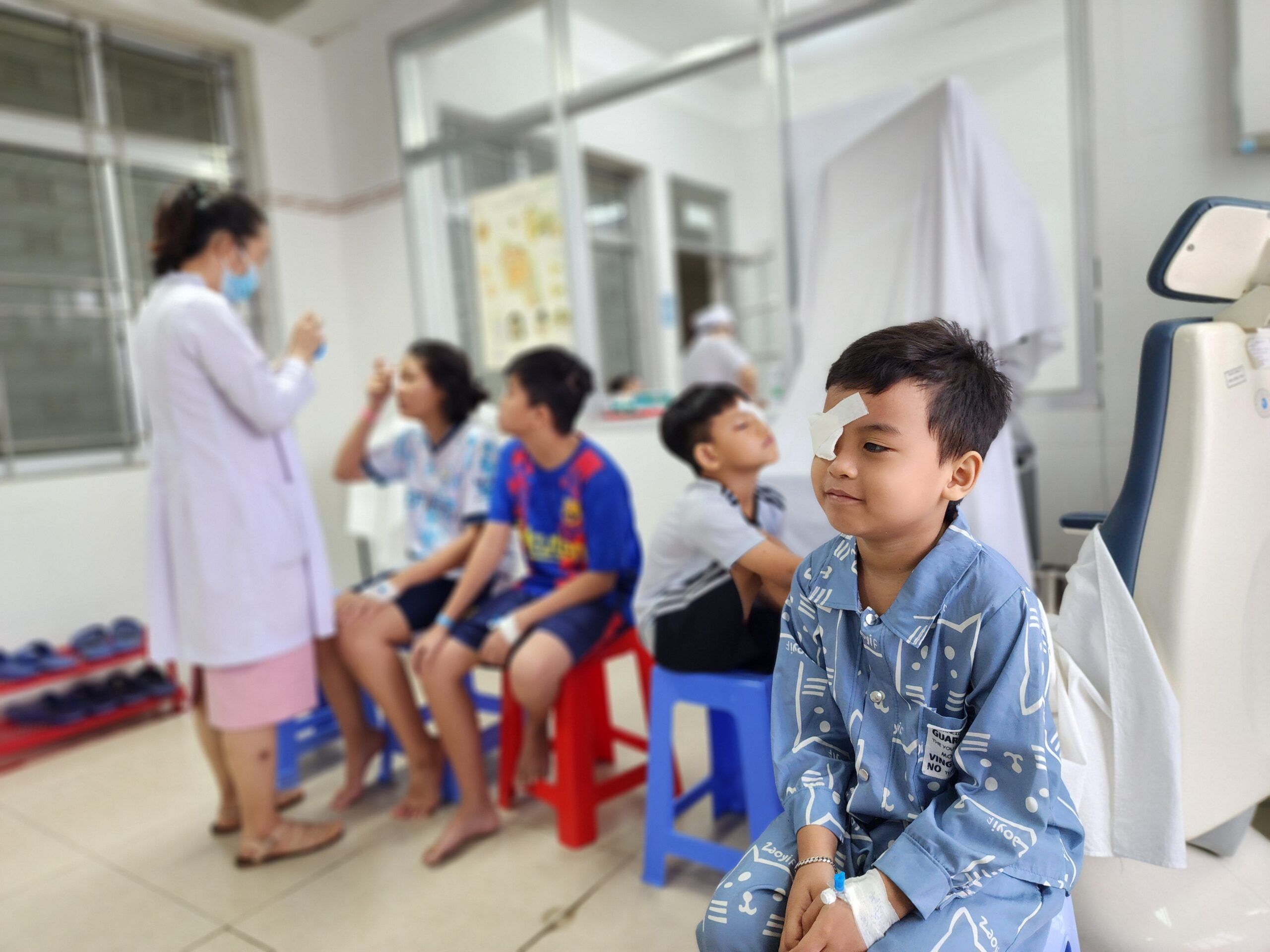 Drie meisjes in Vietnam doen het oogteken met hun hand