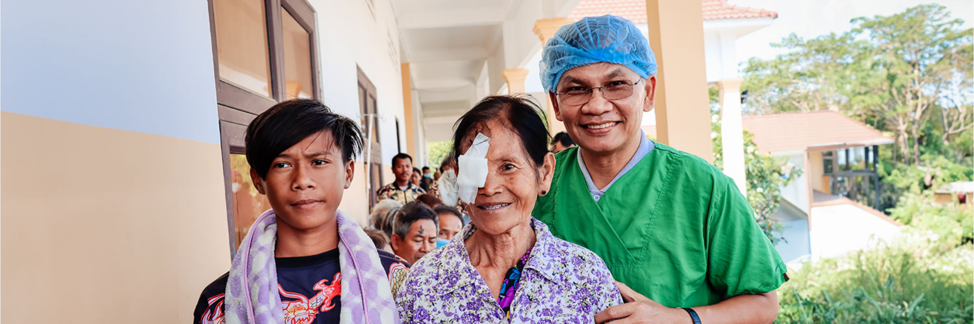 Slechtziende oma met kleinzoon en oogarts in een kliniek in Cambodja