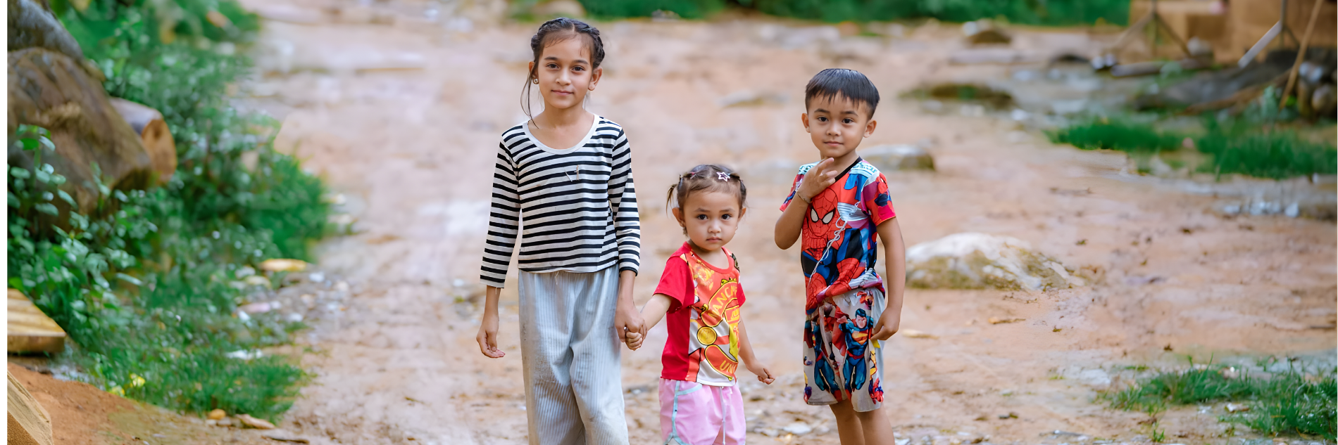 Drie kinderen hand in hand op straat